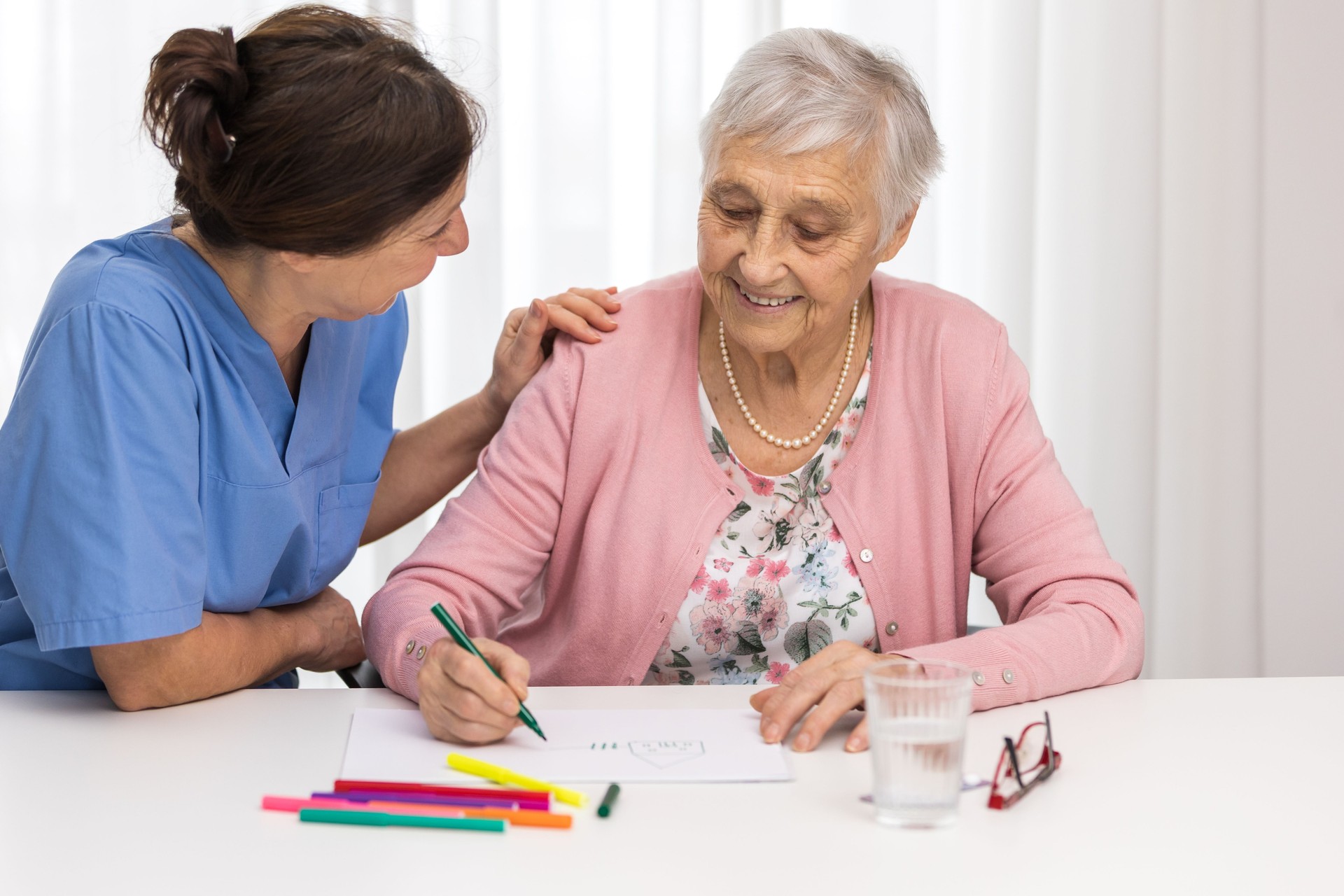 Nursing home therapy- senior woman drawing on white paper