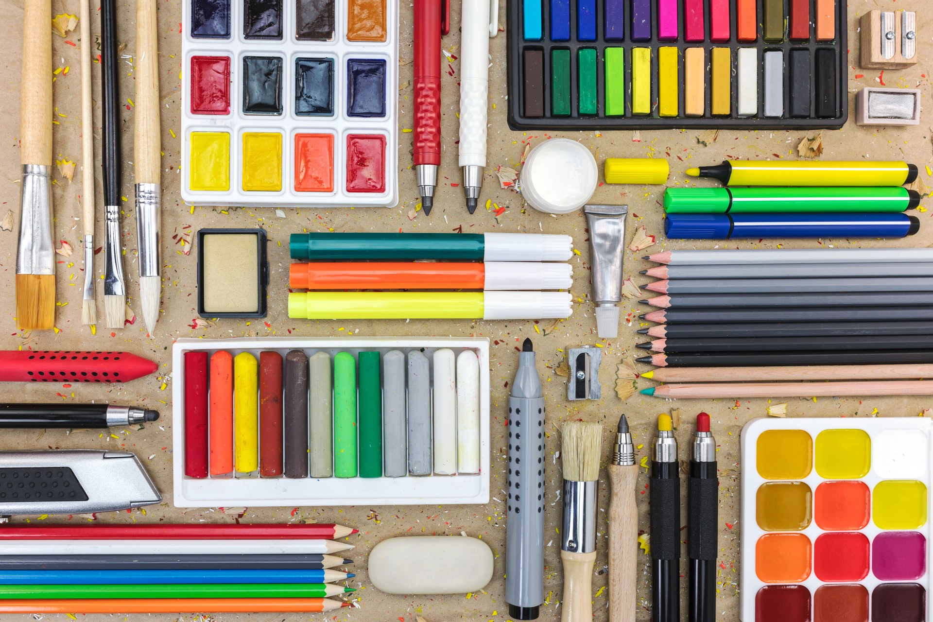 set of different drawing tools on brown craft paper background. top view