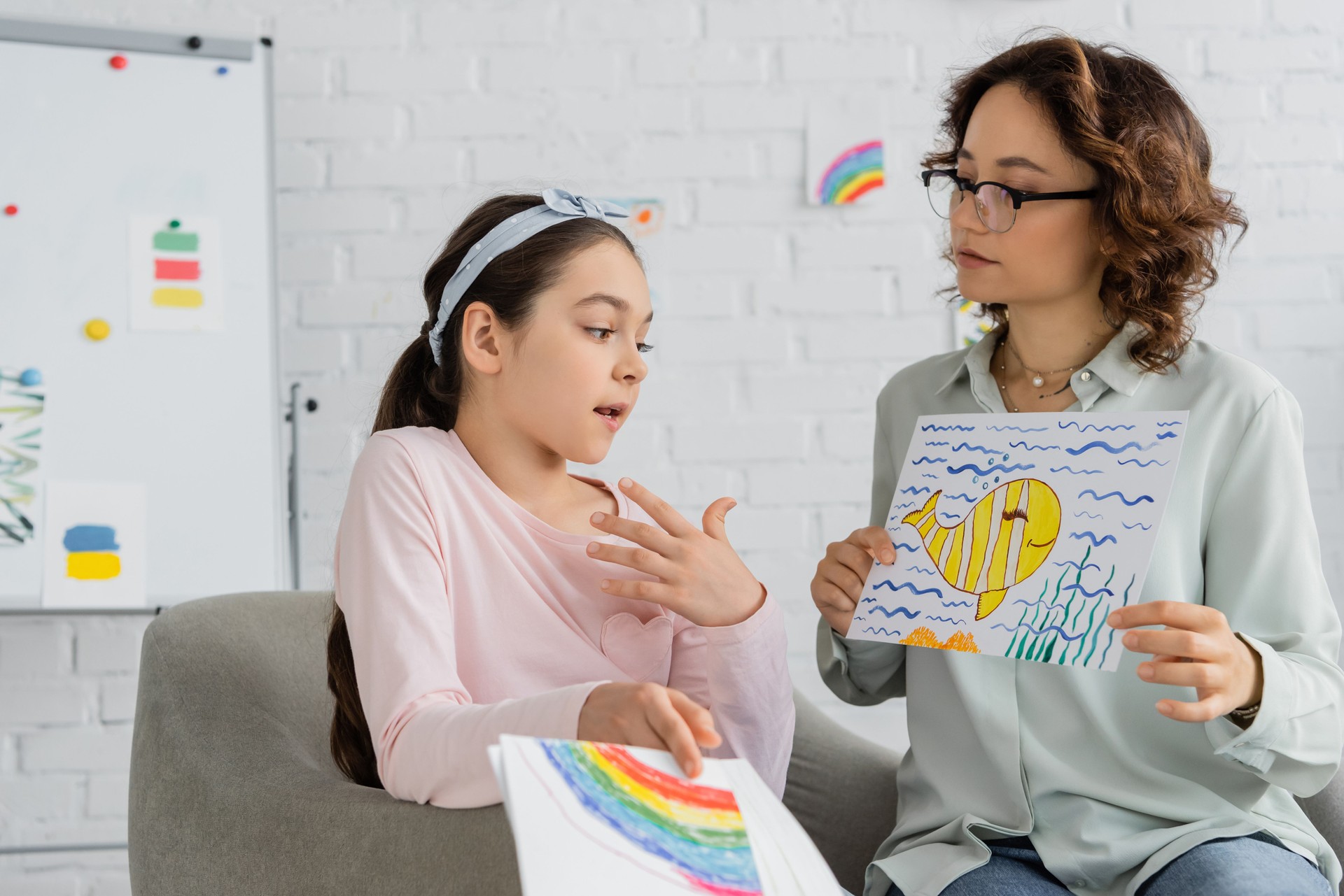 Psychologist engages with child during a creative therapy session in a cozy consulting room